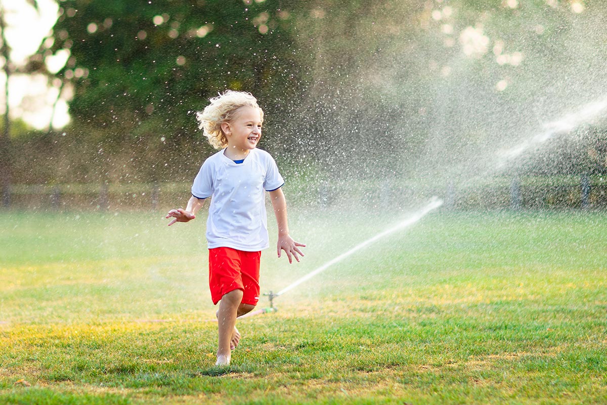 Child Playing With Sprinklers