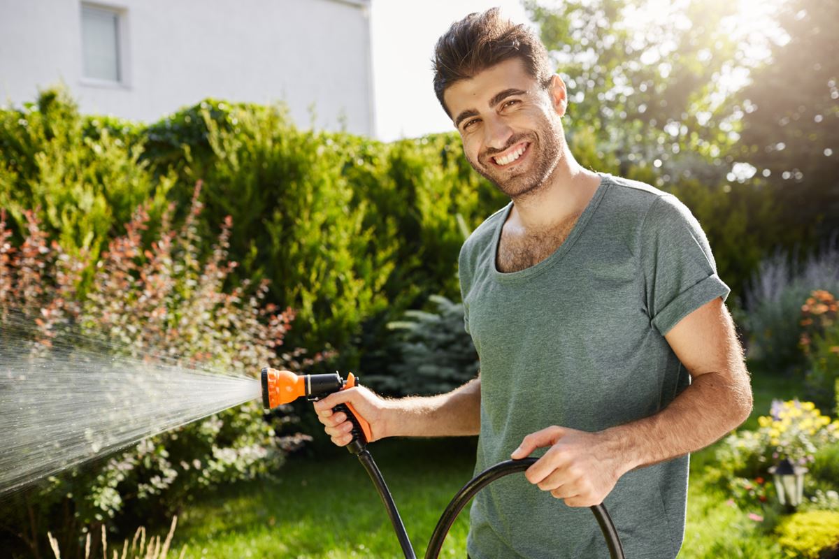 Man Watering A Garden